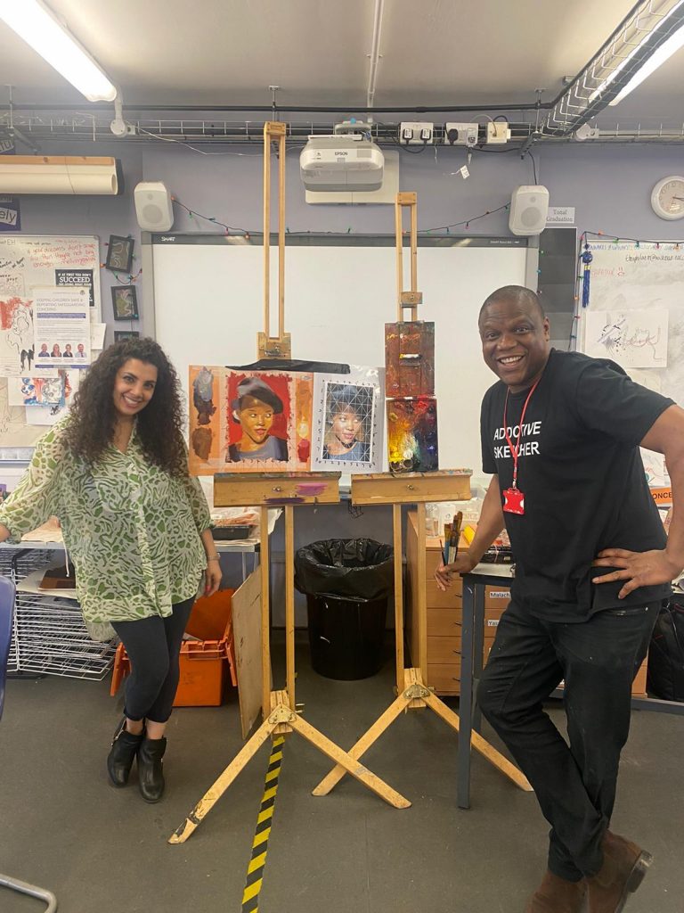 Photo of Abebanji Alade with a pupil next to an easel